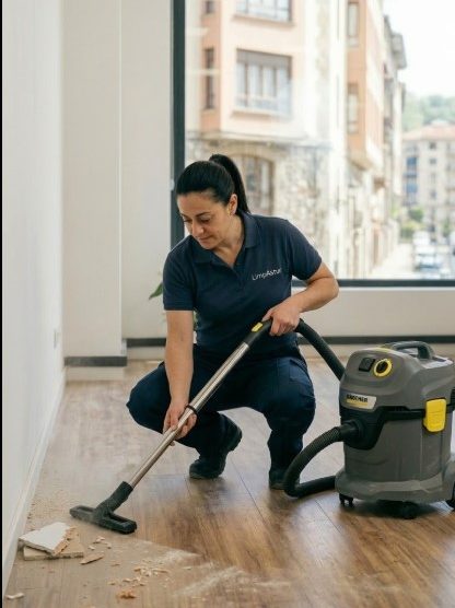 Operaria de LimpAstur uniformada realizando limpieza fin de obra con aspirador industrial Kärcher en una oficina vacía en Oviedo.